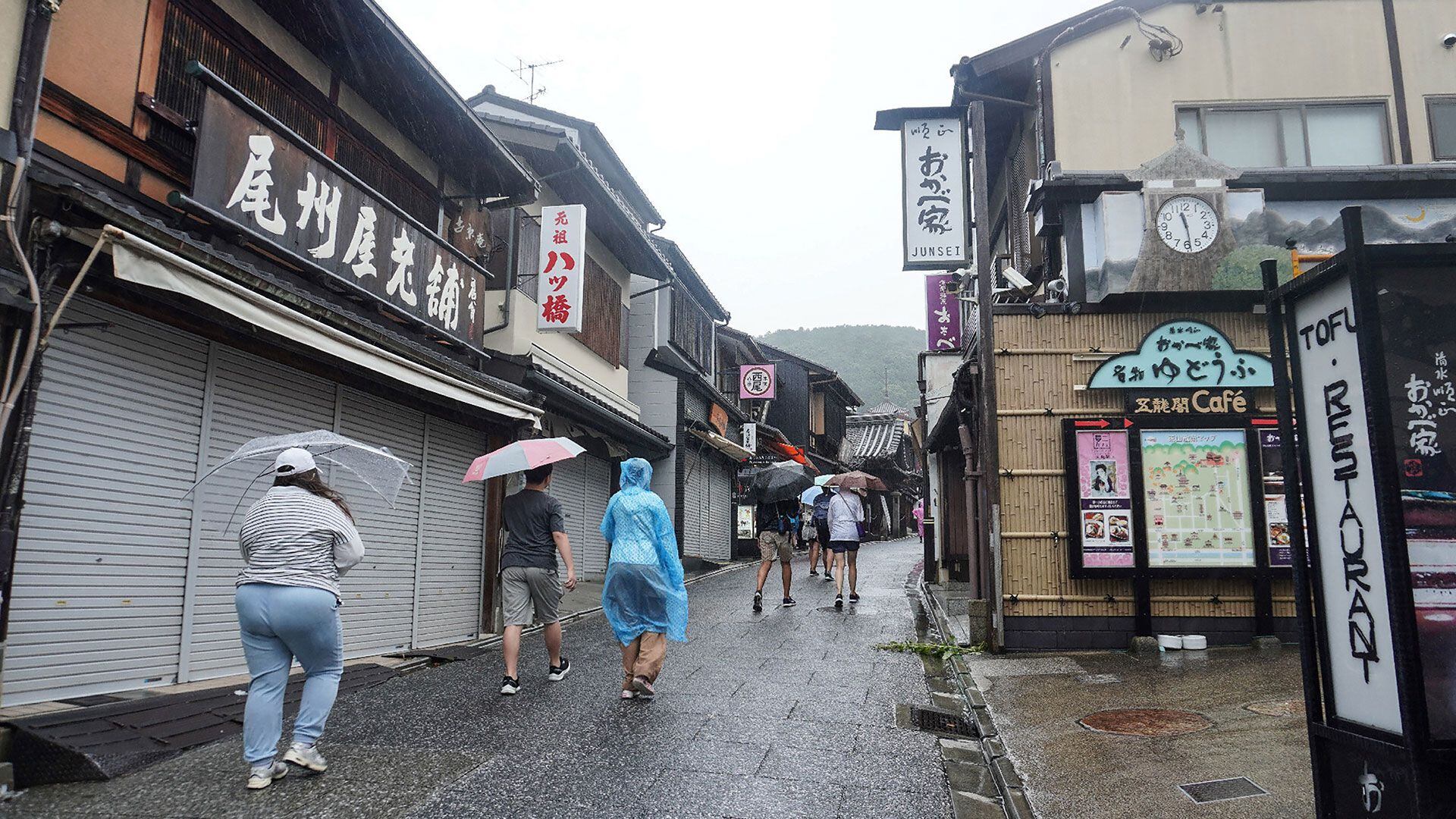 Visitantes suben por una carretera que conduce al popular templo budista de Kiyozimu-dera, normalmente abarrotado de turistas, en Kioto, el 15 de agosto de 2023, mientras la tormenta tropical Lan azotaba la isla principal de Honshu durante la noche, paralizando gran parte de la zona central del país (Foto de JIJI Press / AFP) / Japan OUT