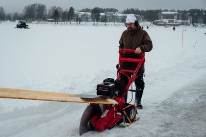 Janne Käpylehto, autor y especialista en energía, autoproclamado inventor del carrusel de hielo, utiliza su última creación "Red Devil" para cortar el hielo y crear el carrusel de hielo. (Alessandro RAMPAZZO / AFP)