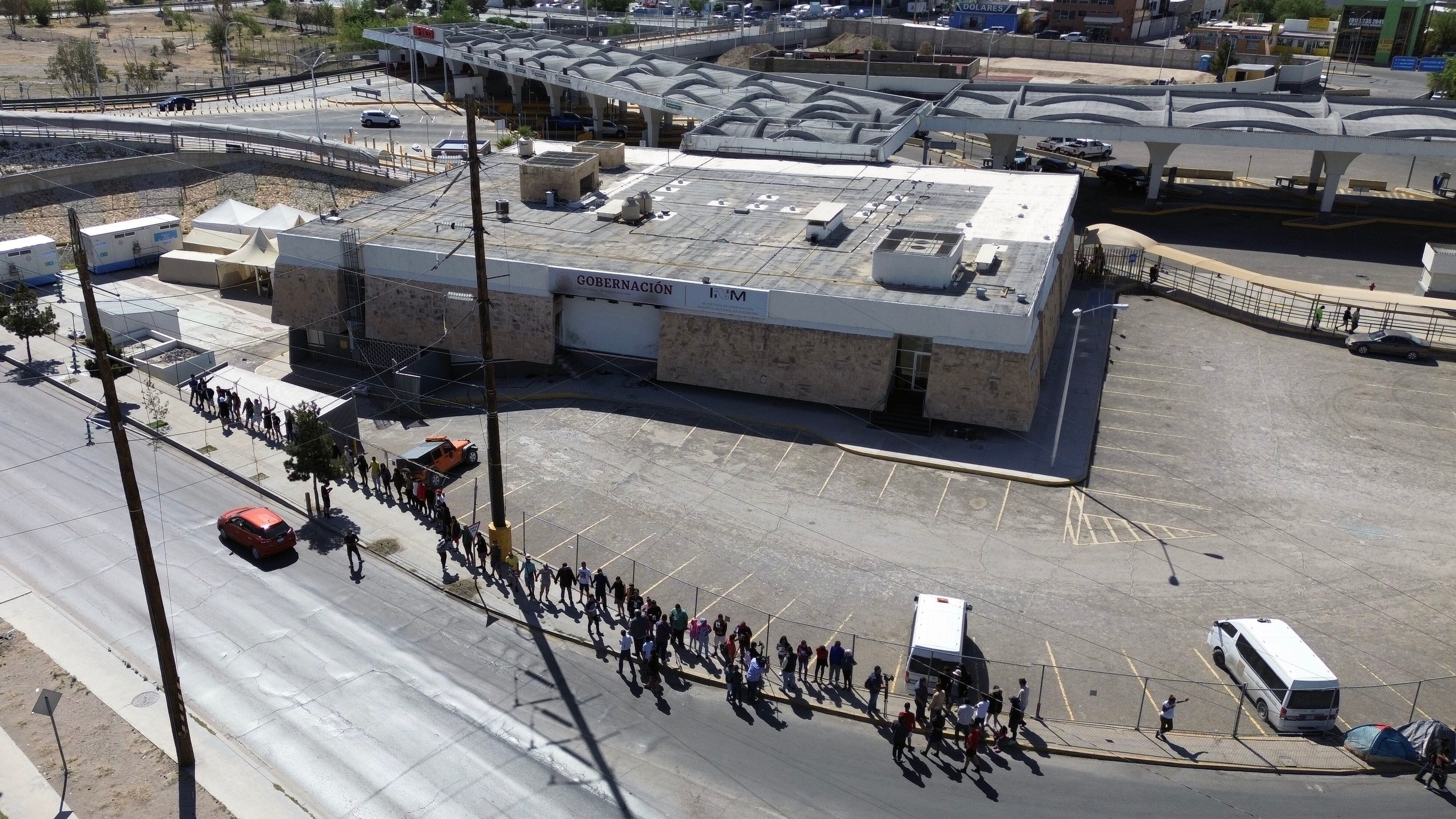 Fotografía aérea de archivo que muestra a migrantes y familiares de los fallecidos en el incendio mientras realizan una vigilia en memoria de las 40 víctimas, frente al Instituto Nacional de Migración (INM) en Ciudad Juárez (México). EFE/Luis Torres