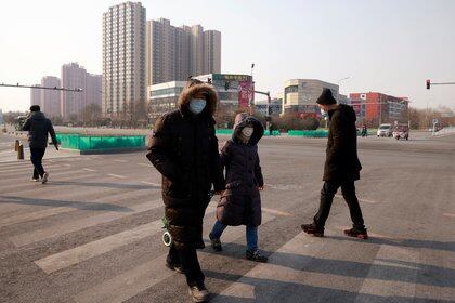 People cross a street following new cases of the coronavirus disease (COVID-19) in Tiangongyuan area of Daxing district in Beijing, China, January 20, 2021. REUTERS/Thomas Peter