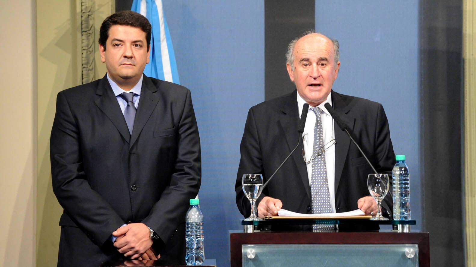 El actual secretario de Justicia, Juan Martín Mena, junto a Oscar Parrilli en el anuncio de la creación de la Agencia Federal de Inteligencia en 2015 (Foto archivo: Télam)