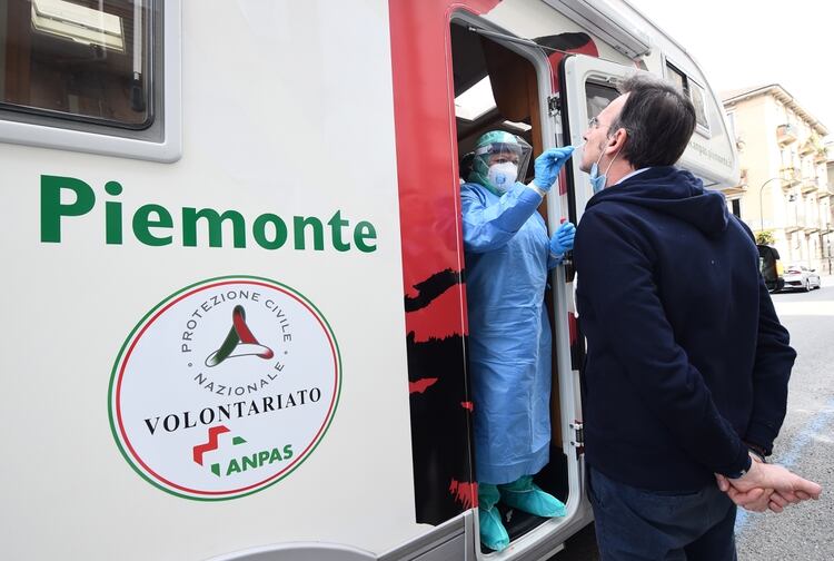 Un trabajador médico realiza una prueba por coronavirus sobre un hombre en Turín (REUTERS/Massimo Pinca)
