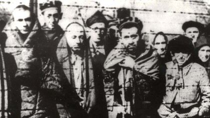 Holocaust survivors are seen behind a barbed wire fence after the liberation of the Nazi German death camp Auschwitz-Birkenau in 1945 in Nazi-occupied Poland, in this handout picture obtained by Reuters on January 19, 2020. Courtesy of Yad Vashem Archives/Handout via REUTERS ATTENTION EDITORS - THIS IMAGE WAS PROVIDED BY A THIRD PARTY.