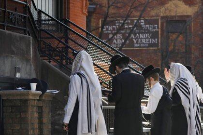 Judíos jasídicos se reúnen para orar afuera de una sinagoga cerrada por coronavir en Williamsburg, Brooklyn (REUTERS / Andrew Kelly)