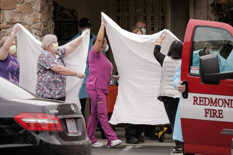 Médicos y otros trabajadores de la sanidad trasladan a un paciente en camilla a una ambulancia en el centro LifeCare de Kirkland, el centro de cuidados a largo plazo relacionado con dos de los tres casos de coronavirus confirmados en el estado, en Kirkland, Washington, EEUU [ 1 de marzo de 2020] (Reuters/ David Ryder)
