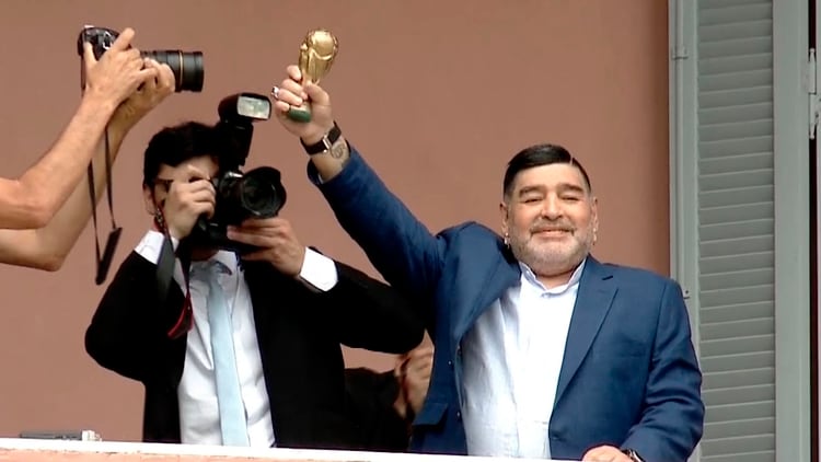 Maradona, con una mini réplica de la Copa del Mundo, 33 años después