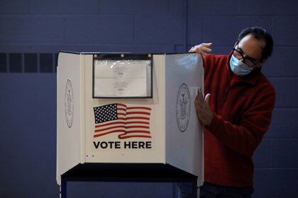 Un hombre desinfecta una máquina de votación en la ciudad de Nueva York (REUTERS / Andrew Kelly)