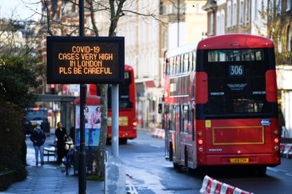 Los autobuses pasan un cartel con un mensaje de información sobre la salud pública, en medio de la propagación de la enfermedad del coronavirus (COVID-19), a medida que entran en vigor nuevas restricciones, en Londres, Gran Bretaña, el 20 de diciembre de 2020. REUTERS/Toby Melville