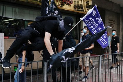 Un manifestante salta una reja durante protestas en Hong Kong, en desafío a la nueva ley de seguridad promulgada por China.  Julio 1, 2020. REUTERS/Tyrone Siu