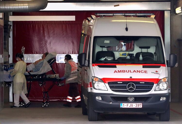 Médicos con máscaras protectoras llevan a un paciente en una camilla en el Hospital Onze Lieve Vrouw en Aalst, Bélgica (Reuters)