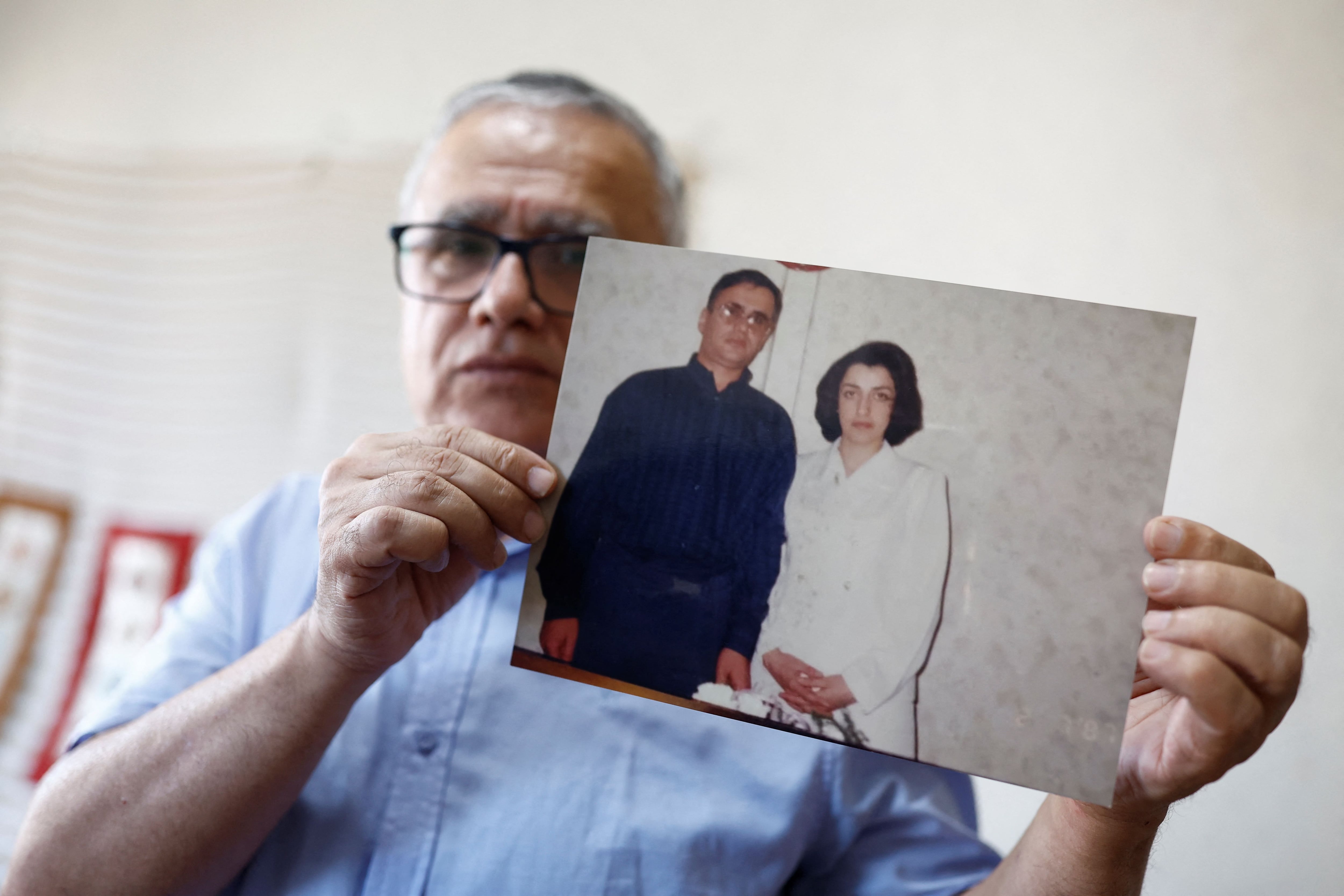 Taghi Ramahi, esposo de Narges Mohammadi, exhibe una imagen junto a su esposa durante una entrevista en Francia (REUTERS/Christian Hartmann)