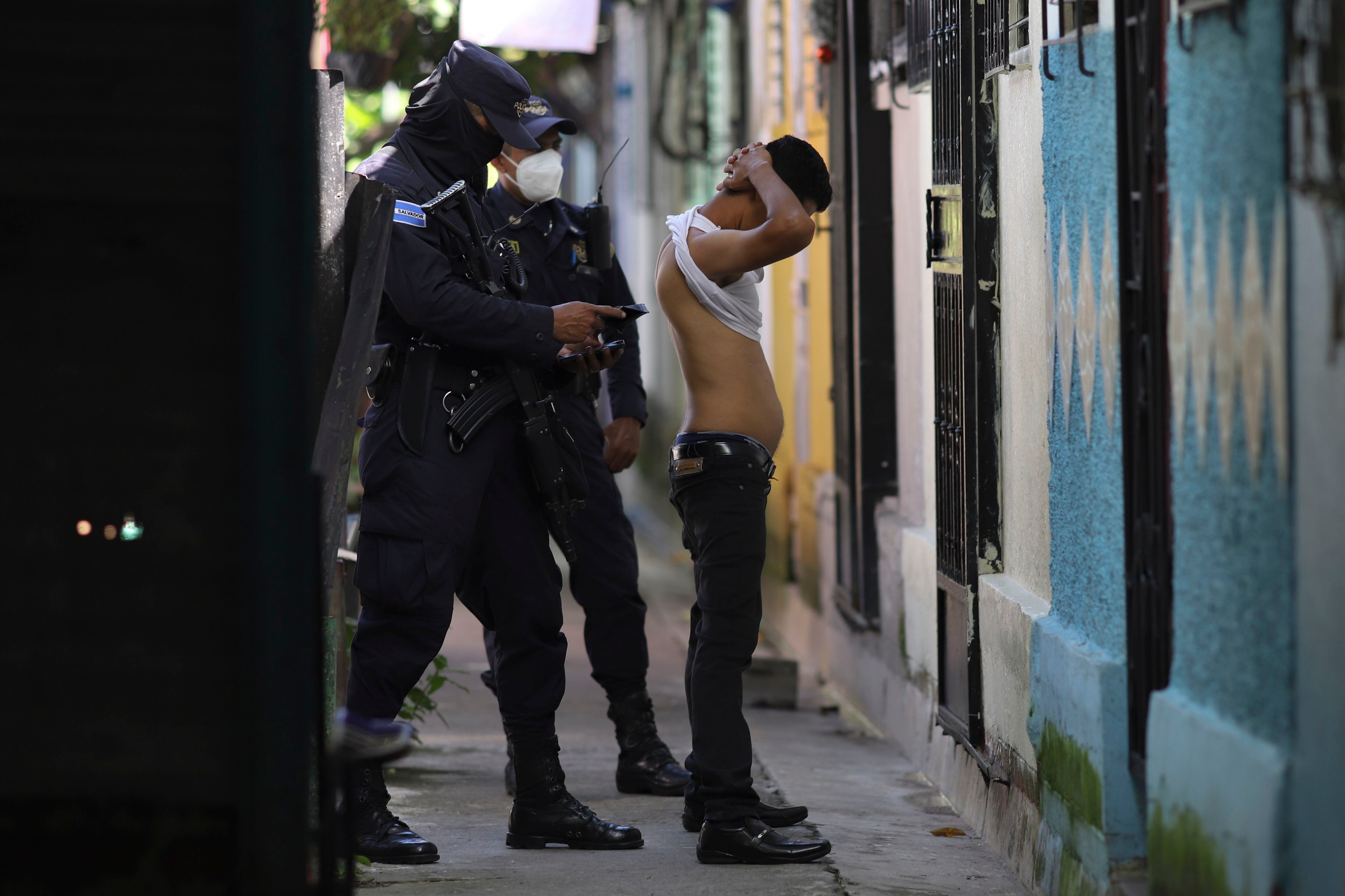 Un policía registra la documentación de un hombre que vive en la comunidad de Kiwanis durante una patrulla preventiva contra las pandillas en Soyapango, El Salvador (AP Foto/Salvador Melendez/Archivo)