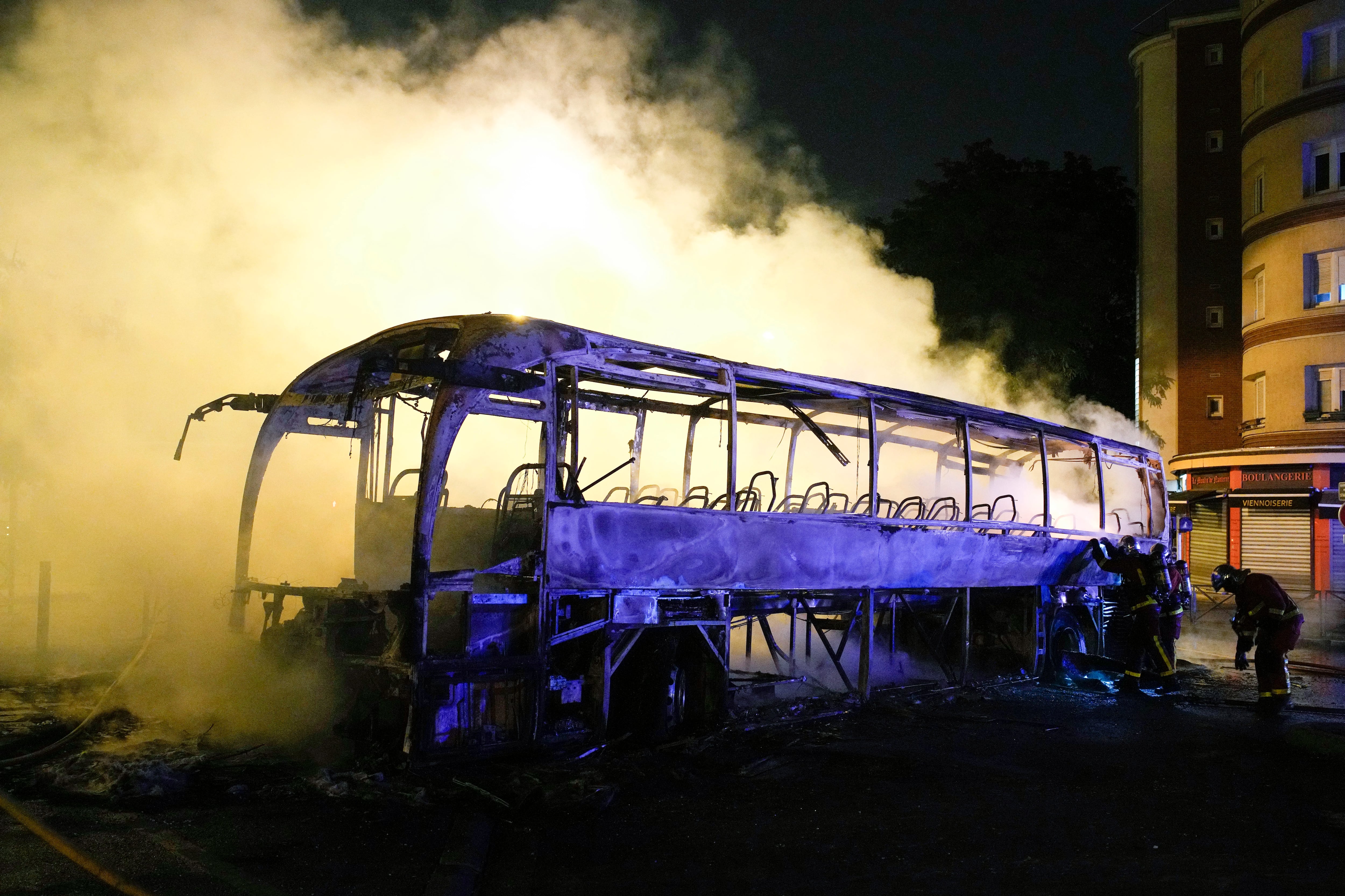 Bomberos arrojan agua a un autobús quemado en Nanterre, en las afueras de París, Francia. (AP Foto/Lewis Joly)