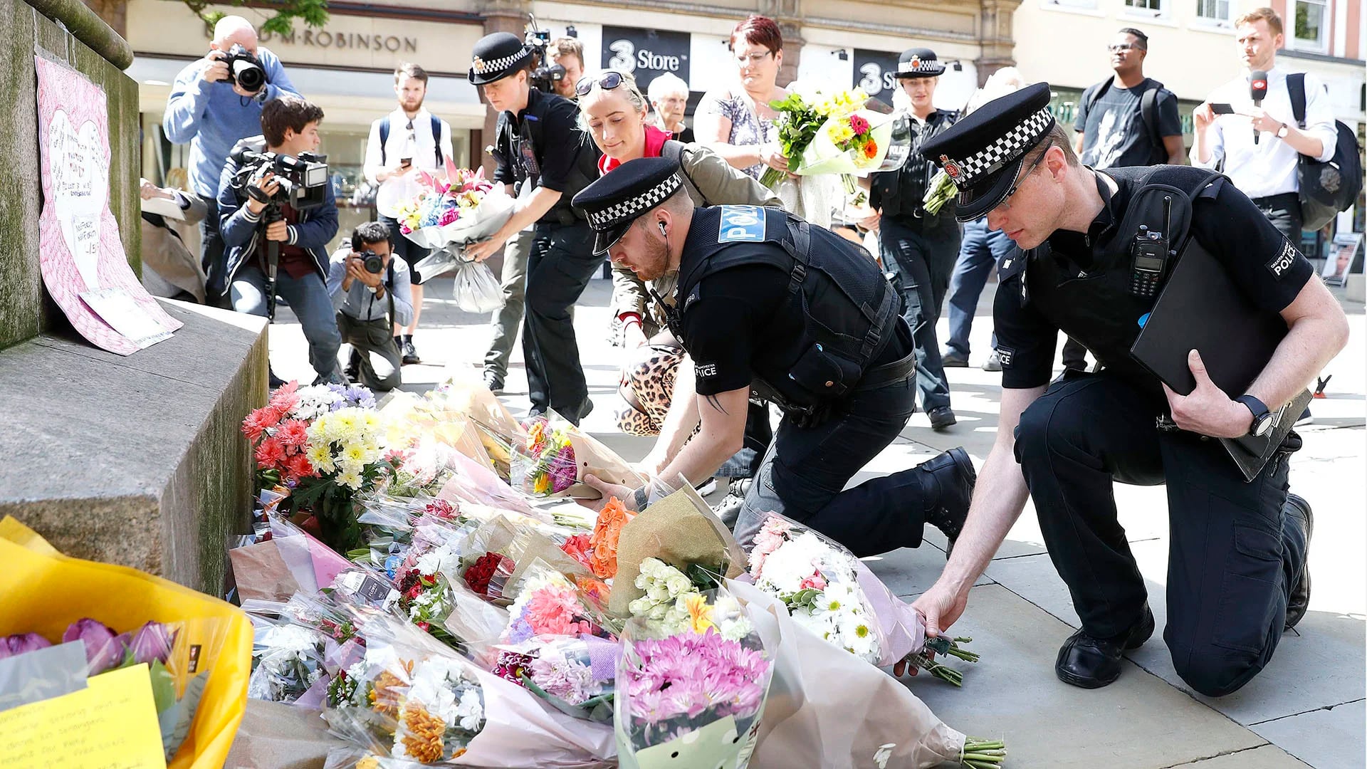 Policías británicos dejan flores en el centro de Manchester (AP)