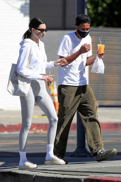 Kendall Jenner fue vista en el centro de West Hollywood cuando salía de una tienda con un amigo. Compraron un jugo y comida para llevar. Lució una campera blanca, calzas grises, medias y ojotas. También llevó puestos anteojos de sol y su tapabocas