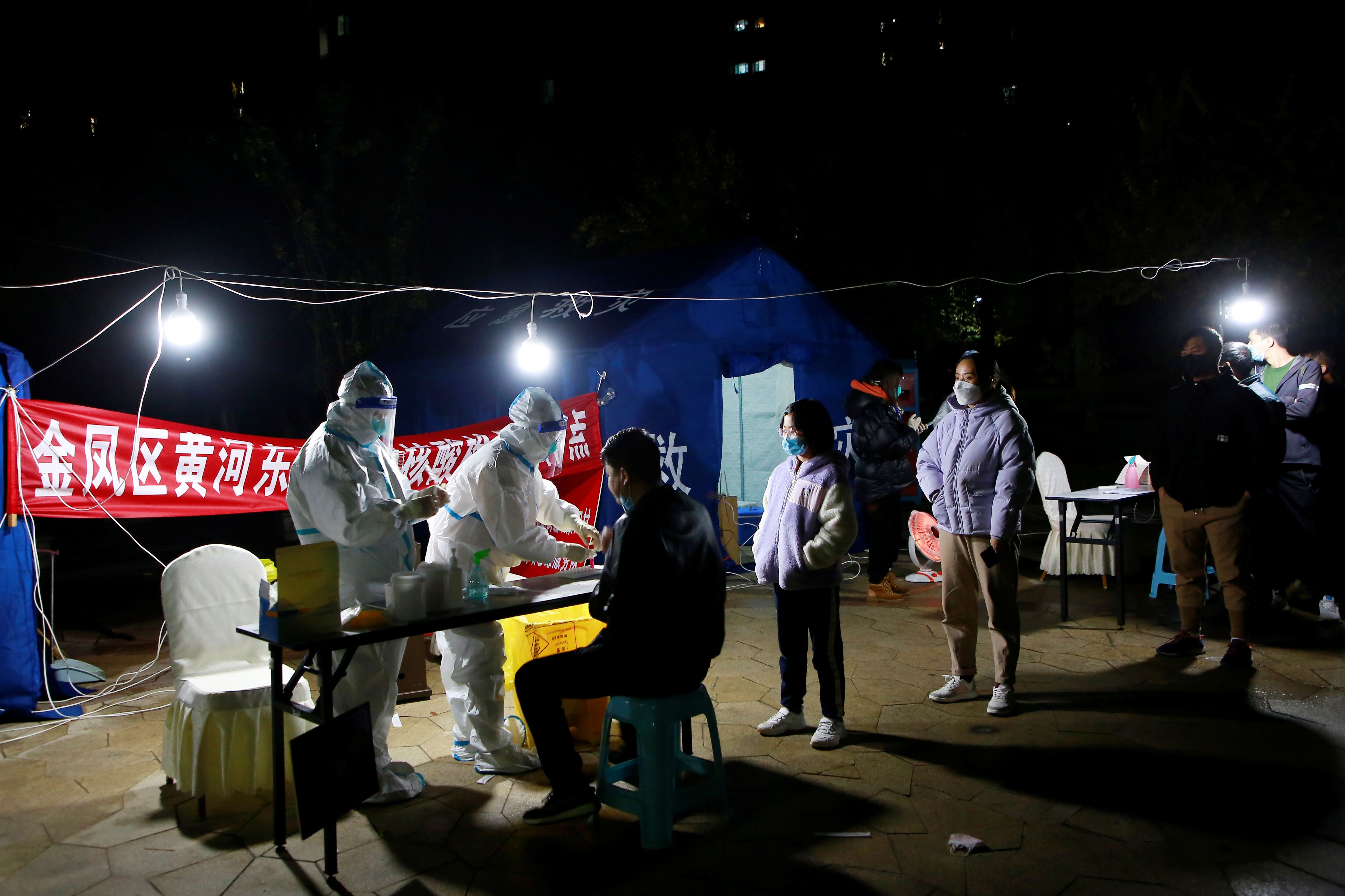 Las personas hacen fila para las pruebas de ácido nucleico en un complejo residencial durante la tercera ronda de pruebas masivas para la enfermedad del coronavirus (COVID-19) en el distrito de Jinfeng de Yinchuan, este lunes (cnsphoto via REUTERS)