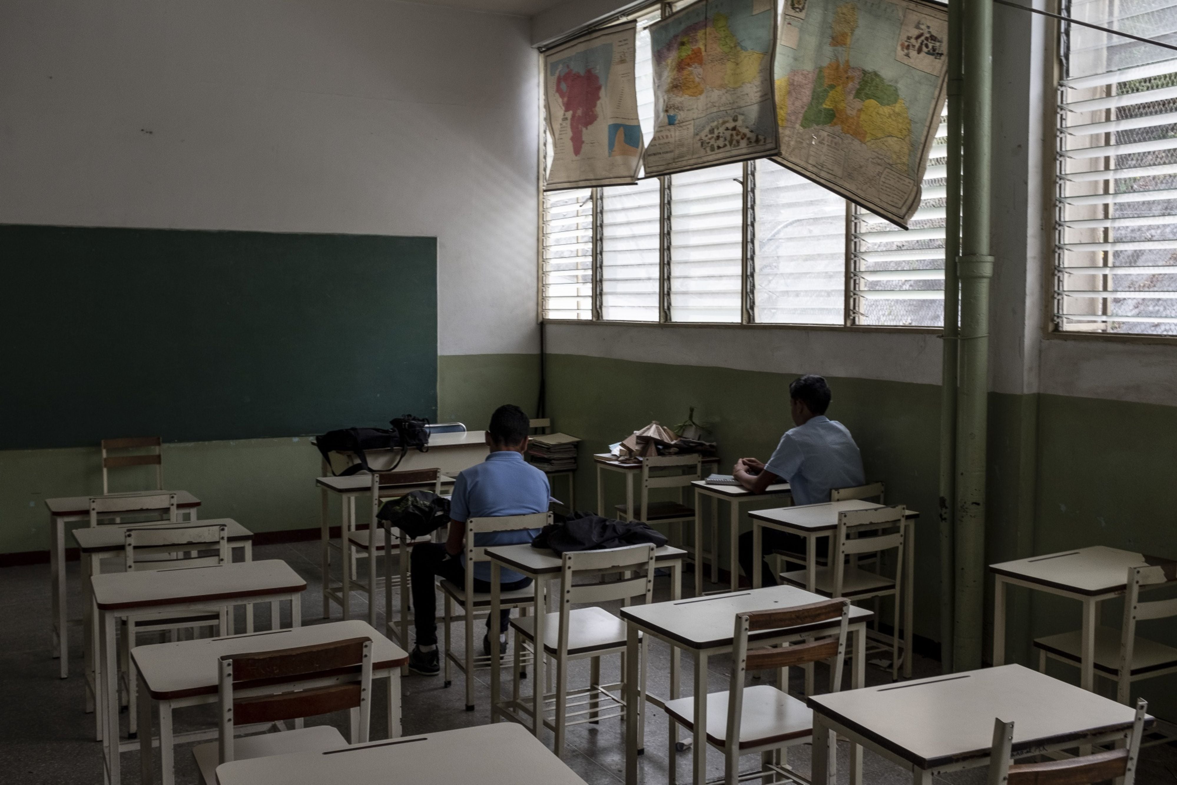 Apenas dos estudiantes sentados en un aula de la escuela Cecilio Acosta en Los Teques, estado de Miranda (Bloomberg) 