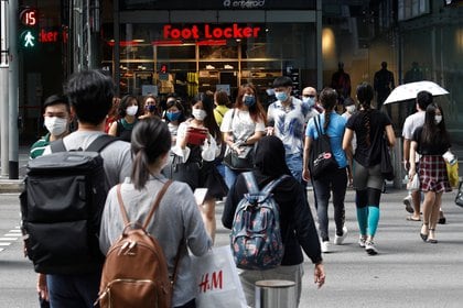 Jóvenes pasean con mascarillas en el distrito comercial de Singapur (Reuters)