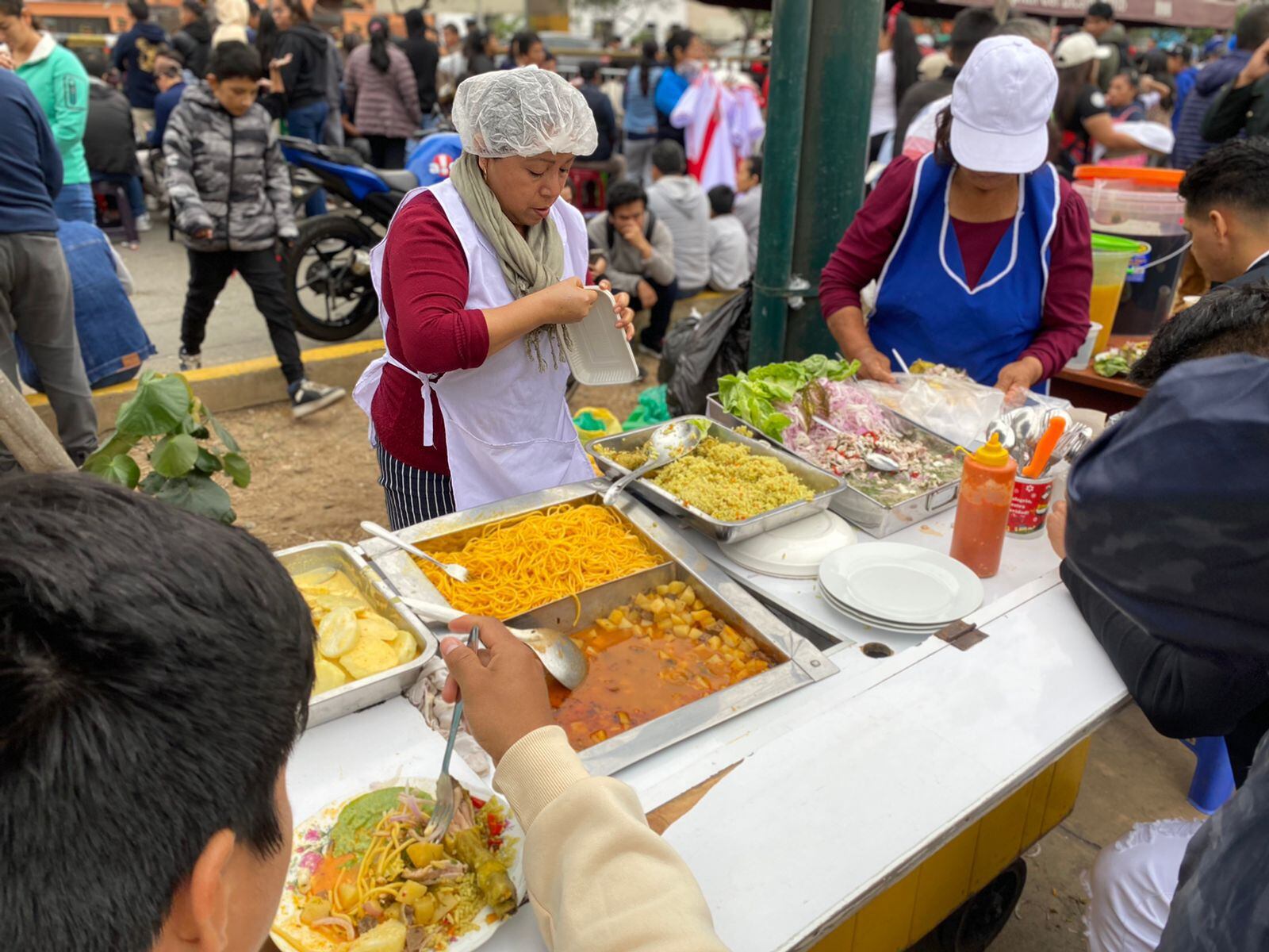 Cientos de personas llegan a la avenida Brasil para el Desfile Militar, pero antes disfrutan de la gastronomía popular peruana| Infobae Perú / Clara Giraldo