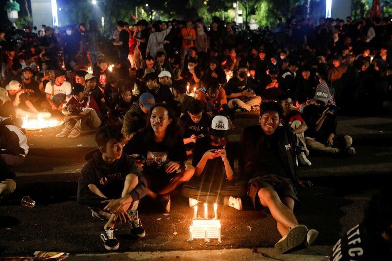 Aficionados al fútbol asisten a una vigilia en la zona del estadio Gelora Bung Karno, tras los disturbios ocurridos después del partido de fútbol entre Arema y Persebaya, en Yakarta (Reuters)