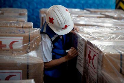 Trabajadores de la Cruz Roja venezolana acomodan las cajas con la ayuda humanitaria en Caracas (Venezuela) (EFE)