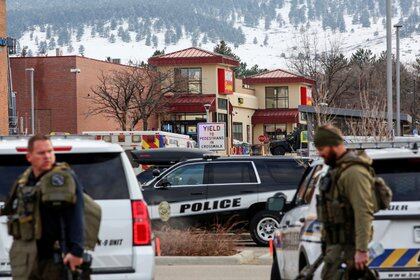 Agentes de la ley se paran en el perímetro del lugar de un tiroteo en una tienda de comestibles King Soopers en Boulder (Reuters)
