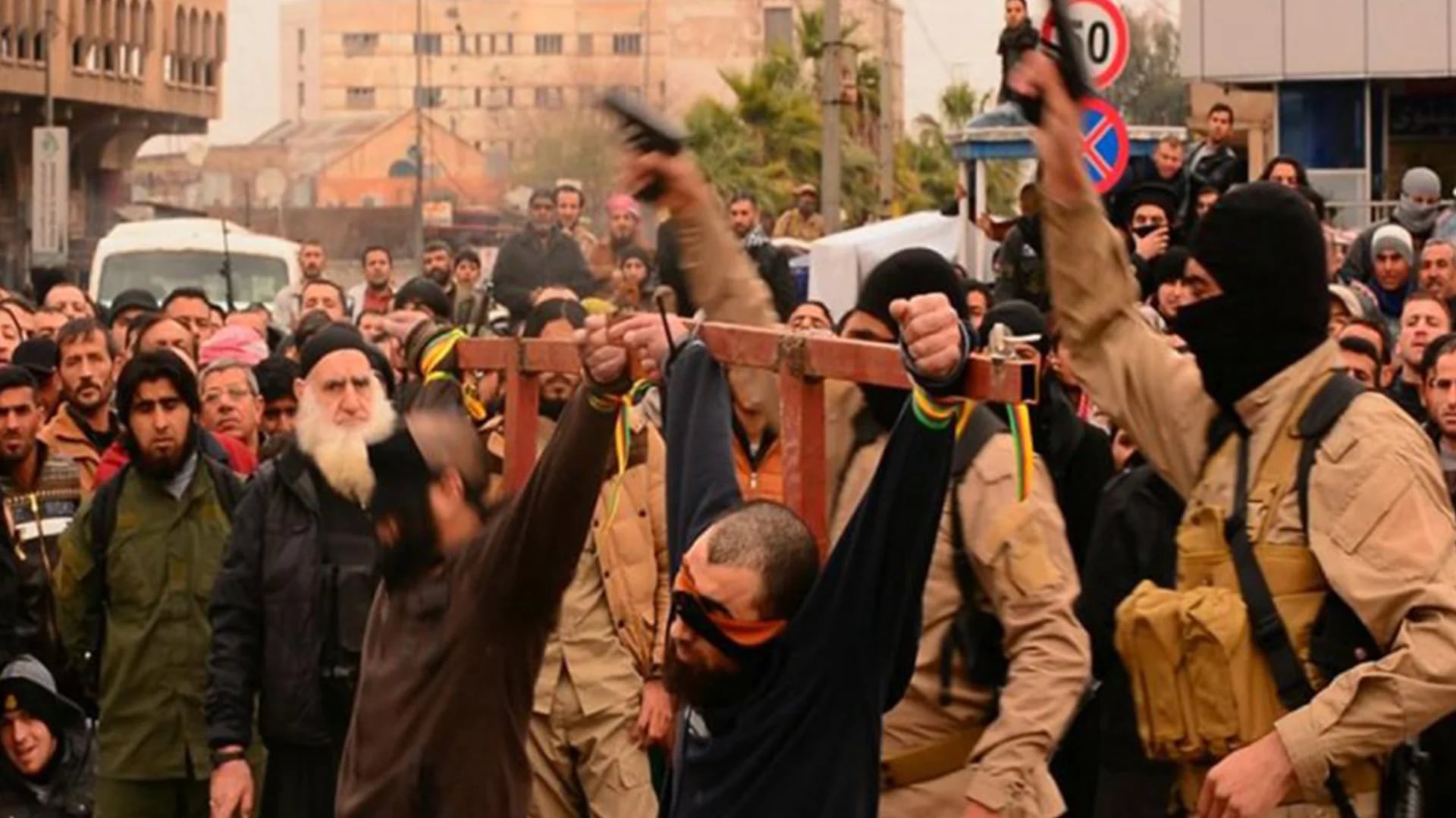 Combatientes del Estado Islámico junto a dos de sus prisioneros