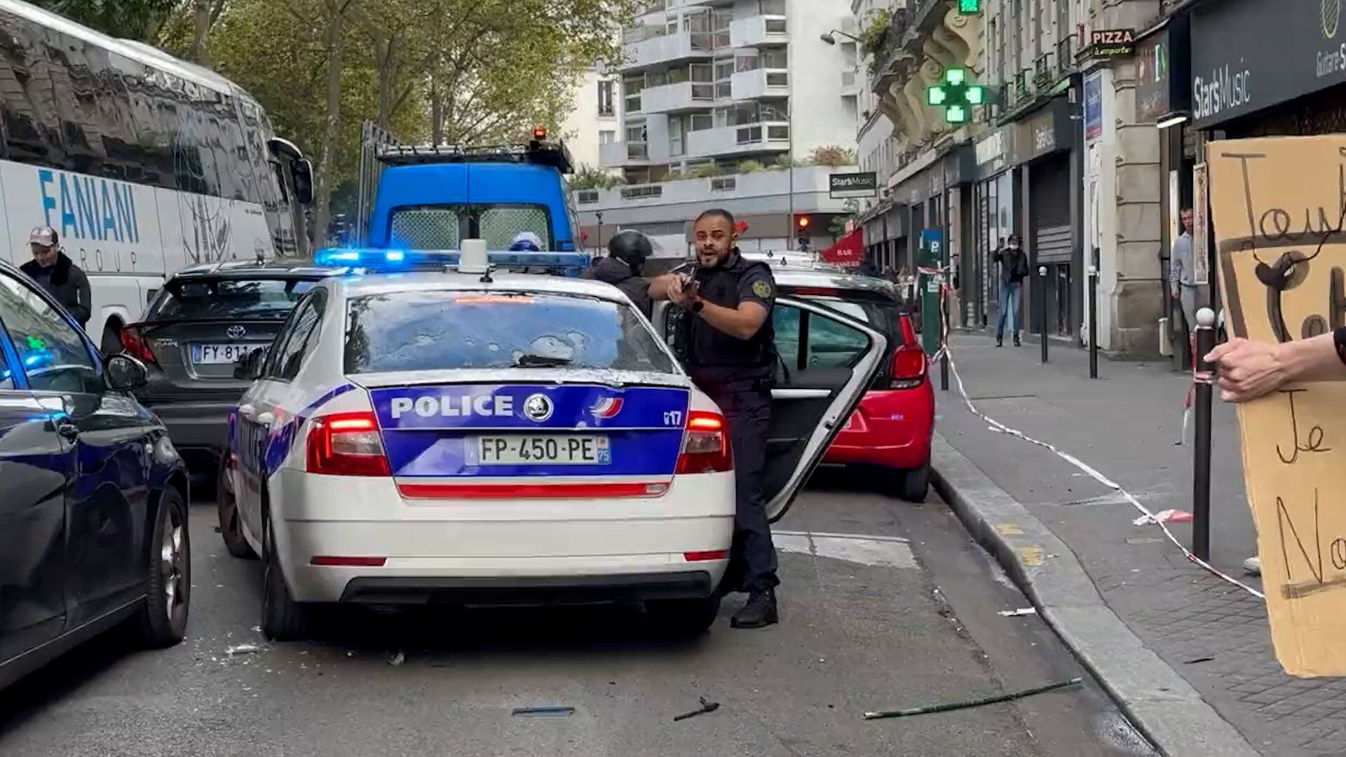 Atrapados por los manifestantes, un policía blandió el arma para intentar disuadir a los atacantes