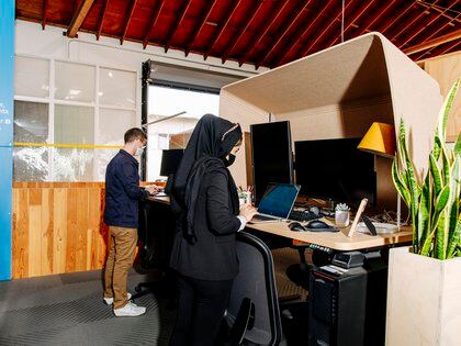 Shokofeh Darbari y Josh Plourde prueban las configuraciones del escritorio en el laboratorio de I + D de la oficina de Google que permite que los conductos de aire se muevan fácilmente y se adapten a los nuevos diseños en el campus de Google en Mountain View. (Cayce Clifford/The New York Times)