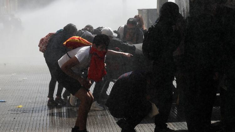Manifestantes se cubren ante el avance de las fuerzas de seguridad (Reuters)