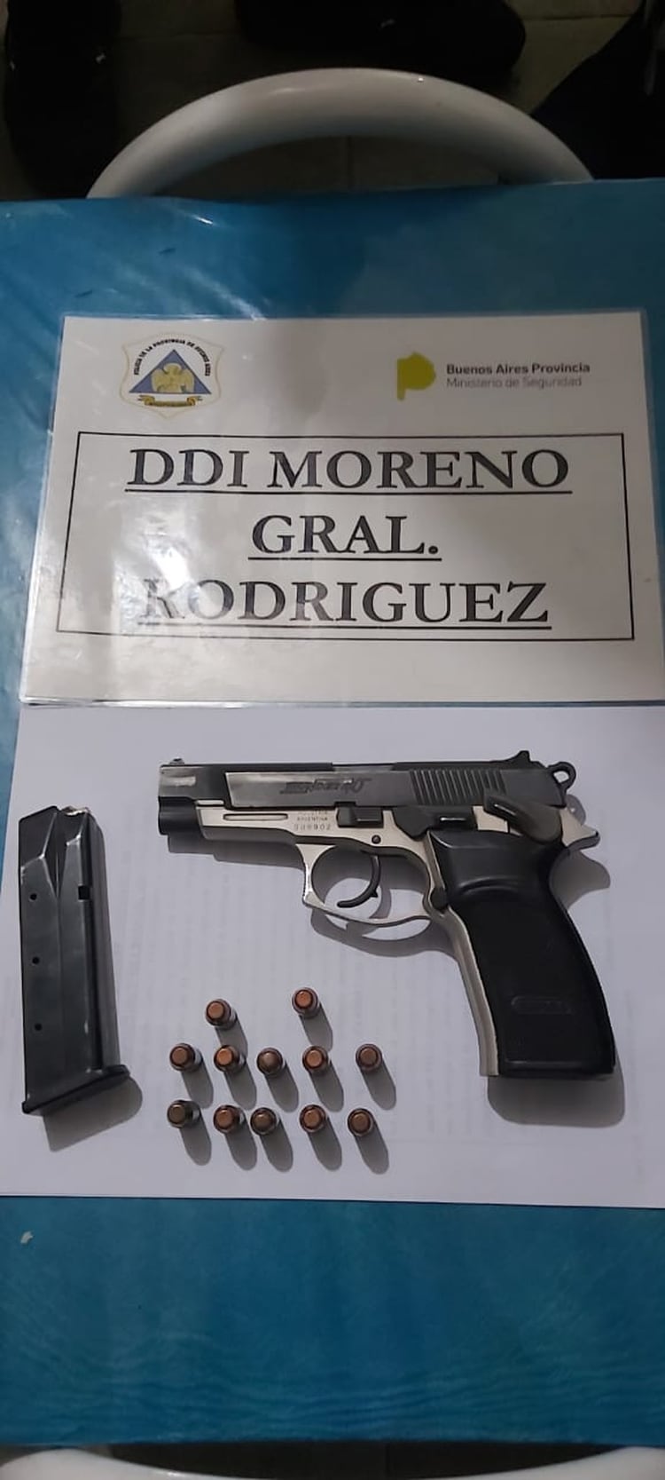 La pistola marca Bersa calibre .40 que había en la casa de Paredes con una remera negra con la inscripción “Policía” y un handy