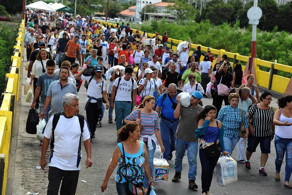 Más de 130.000 personas cruzaron el domingo a Colombia para comprar alimentos (AFP)