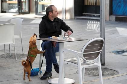 Un hombre con perro sentado en un café,  Ronda, España, 18 mayo 2020.
REUTERS/Jon Nazca