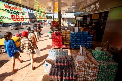 Personas con tapabocas hacen compras en una calle de Brasilia (Brasil). EFE/Joédson Alves/Archivo
