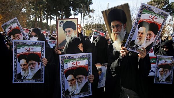 Los manifestantes llevan carteles del primer Líder Supremo de la República Islámica, Ruhollah Khomeini, y del actual Ali Khamenei (AFP)