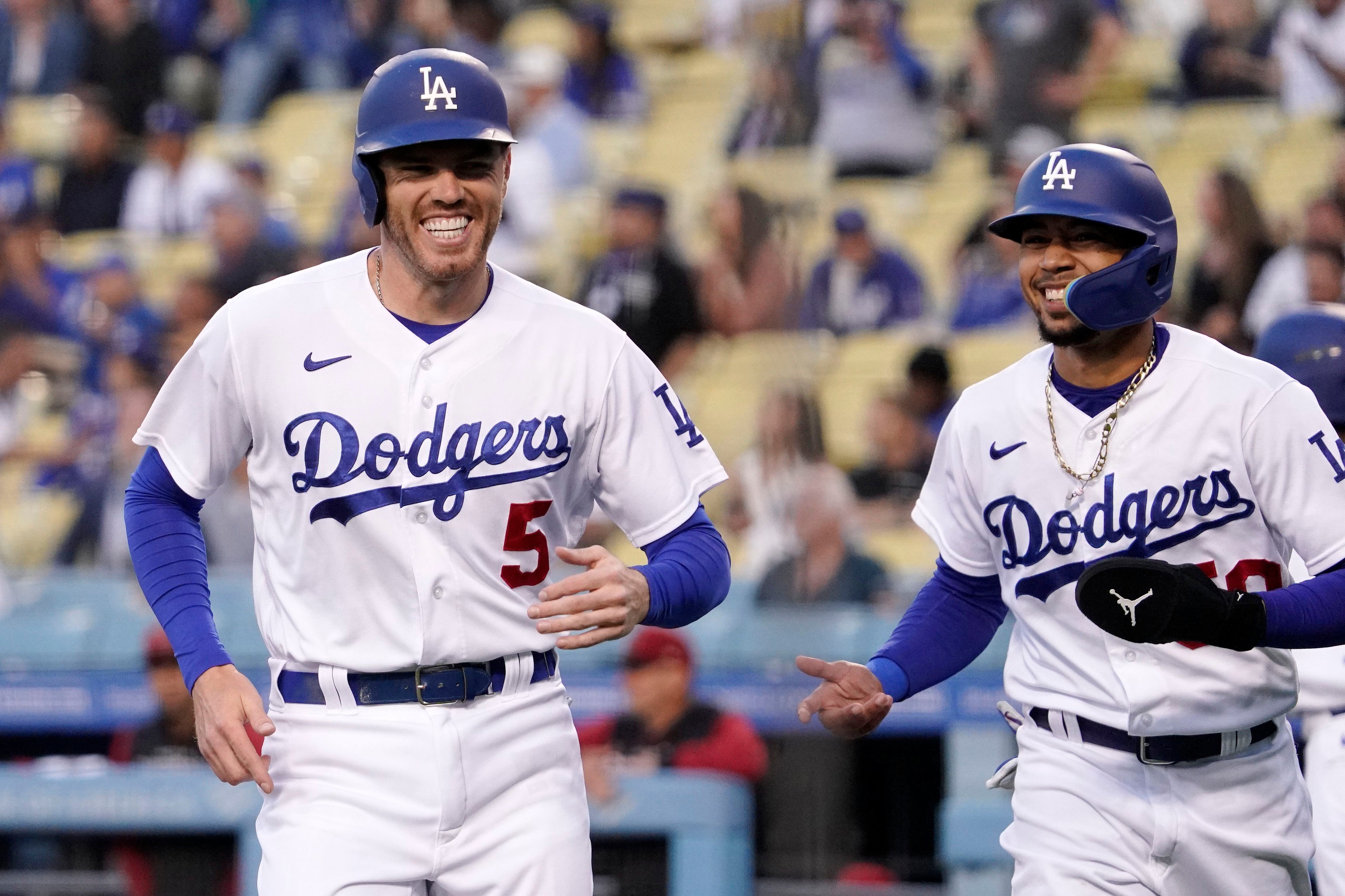 ARCHIVO - Freddie Freeman y Mookie Betts, de los Dodgers de Los Ángeles, ríen tras anotar ante los Diamondbacks de Arizona el 17 de mayo de 2022 (AP Foto/Mark J. Terrill, archivo)
