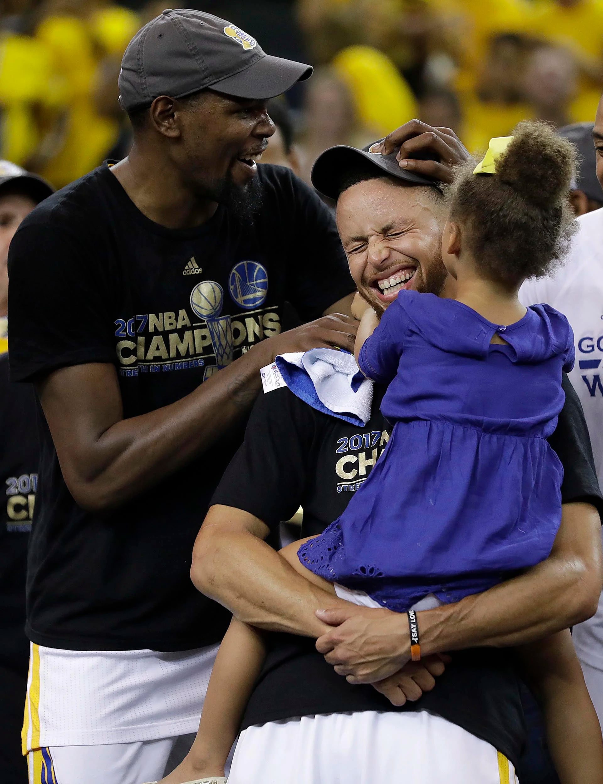 Stephen Curry, con su hija Riley, y Kevin Durant celebran la victoria de Golden State Warriors contra los Cleveland Cavaliers en Oakland, California, que los consagró como campeones de la NBA