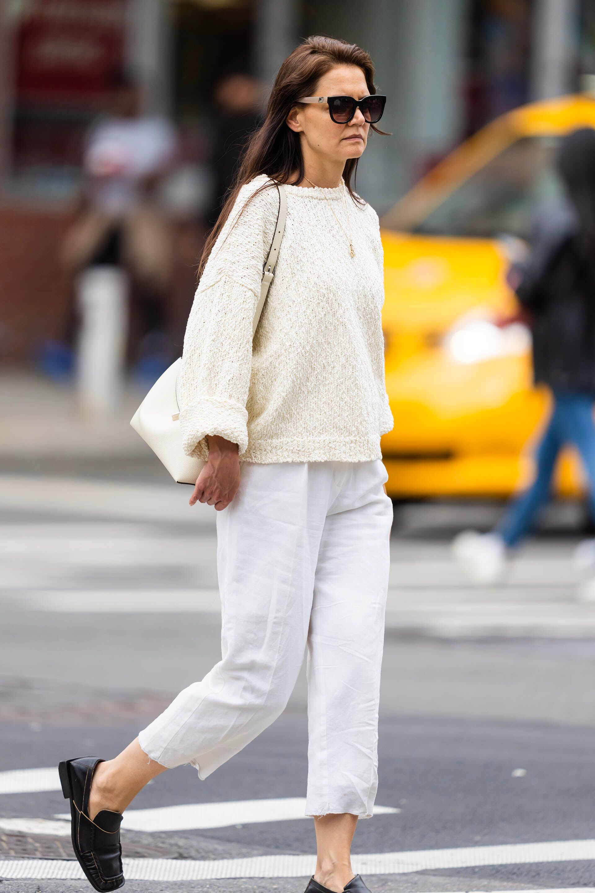 Katie Holmes fue fotografiada mientras daba un paseo por su vecindario en Nueva York. La actriz lució un look off white de sweater, pantalón capri de lino, cartera de cuero. En tanto, usó mocasines negros de cuero y llevó lentes de sol