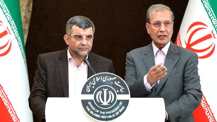 Una fotografía de la presidencia iraní muestra al viceministro de salud de Irán, Iraj Harirchi (izquierda) de pie junto al portavoz del gobierno de la República Islámica, Ali Rabiei, durante una conferencia de prensa en Teherán el 24 de febrero (AFP)