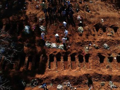 Vista aérea este martes desde un dron, de trabajadores enterrando a una de las víctimas mortales de la pandemia COVID-19 mientras familiares se despiden, en el cementerio de Vila Formosa, el más grande de América Latina, en Sao Paulo (Brasil). (EFE/ PAULO WHITAKER)