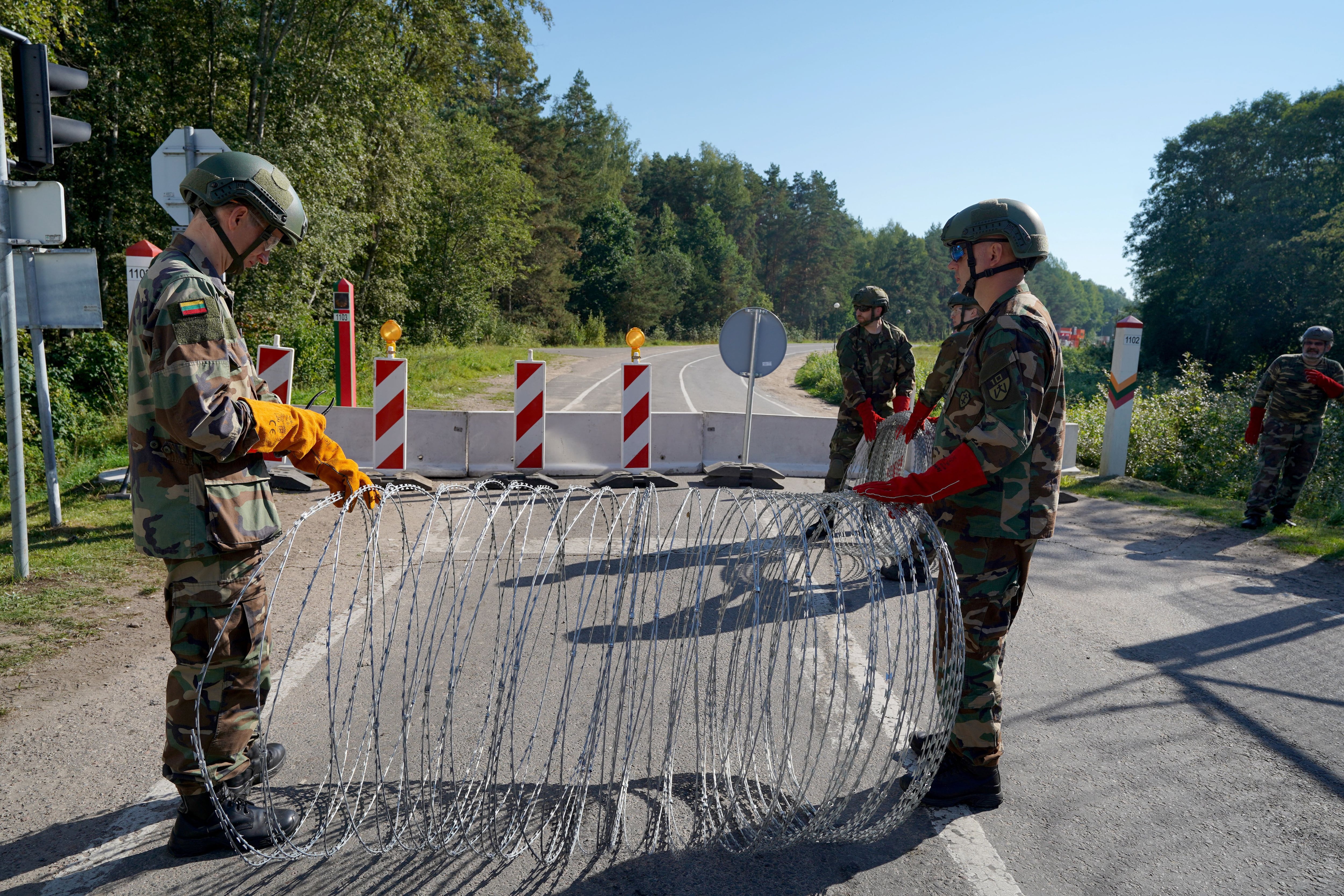 Miembros de la Unión de Fusileros Lituanos instalan alambre de espino en el paso fronterizo con Bielorrusia en Sumskas, Lituania (REUTERS/Janis Laizans)
