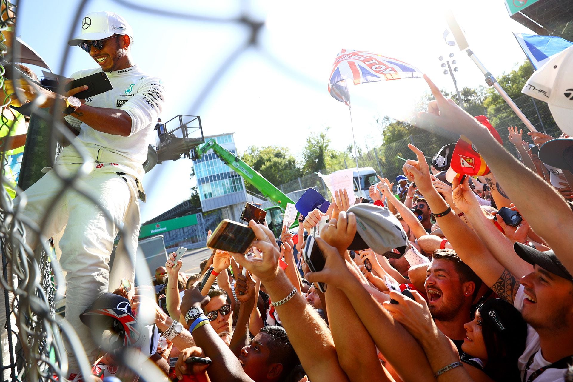 Lewis Hamilton trepando el alambrado de los boxes de Monza para llegar al podio y detrás una multitud. En su momento no fue querido por ganarle siempre a Ferrari, pero por su actitud dentro y fuera de la pista se convertirá en ídolo de los tifosis  (Photo by Dan Istitene/Getty Images)