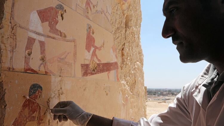 Un arqueólogo egipcio trabaja dentro de una de las tumbas faraónicas más recientemente descubiertas, “Shedsu Djehuty”, en Luxor, Egipto, el 18 de abril de 2019 (REUTERS)