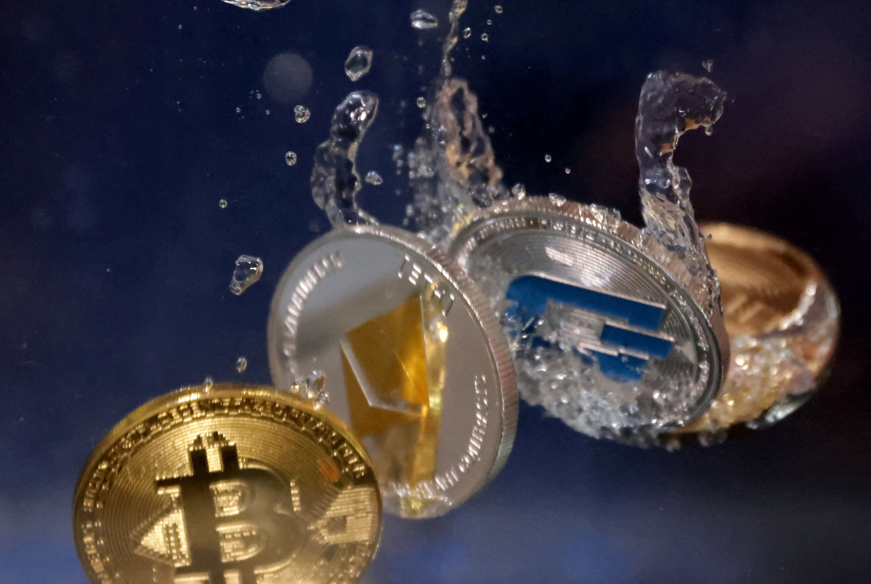 FILE PHOTO: Representations of cryptocurrency Bitcoin, Ethereum and Dash plunge into water in this illustration taken, May 23, 2022. REUTERS/Dado Ruvic/Illustration/File Photo