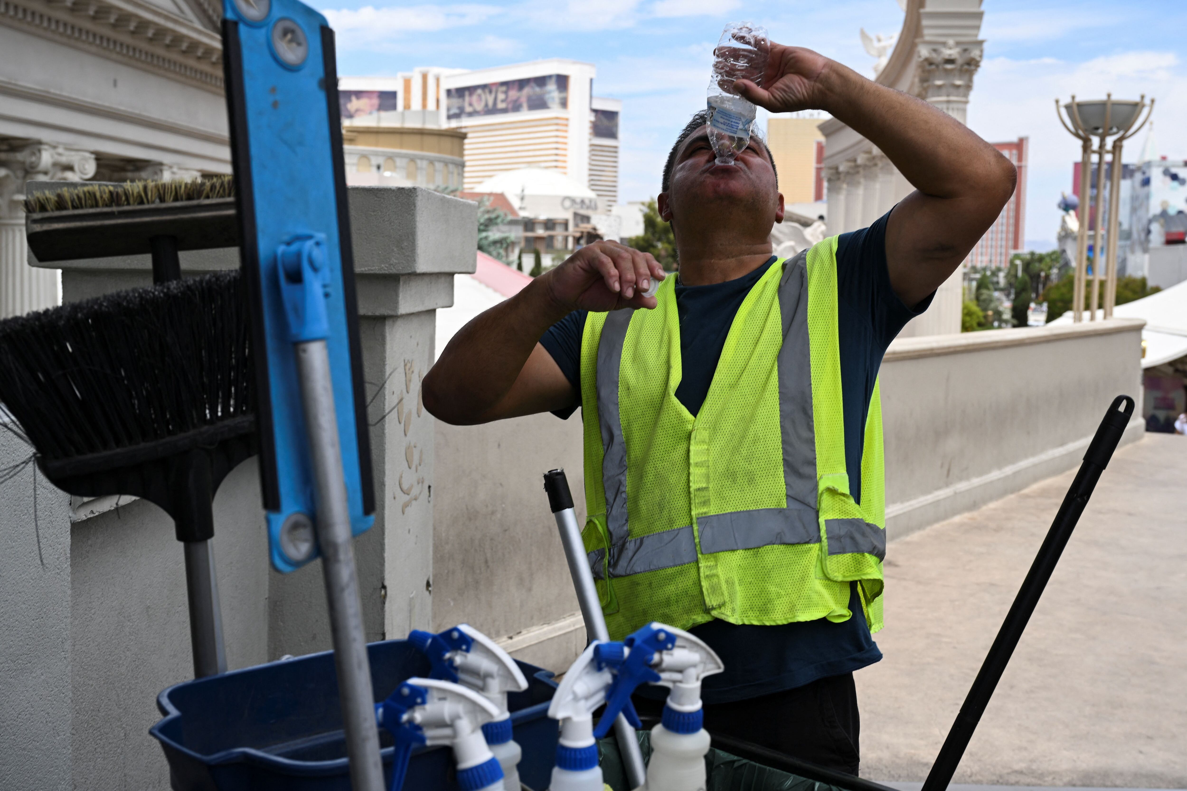 Un hombre hace una pausa para beber mientras trabaja a lo largo del Strip durante una advertencia de calor excesivo en Las Vegas, Nevada, EE.UU