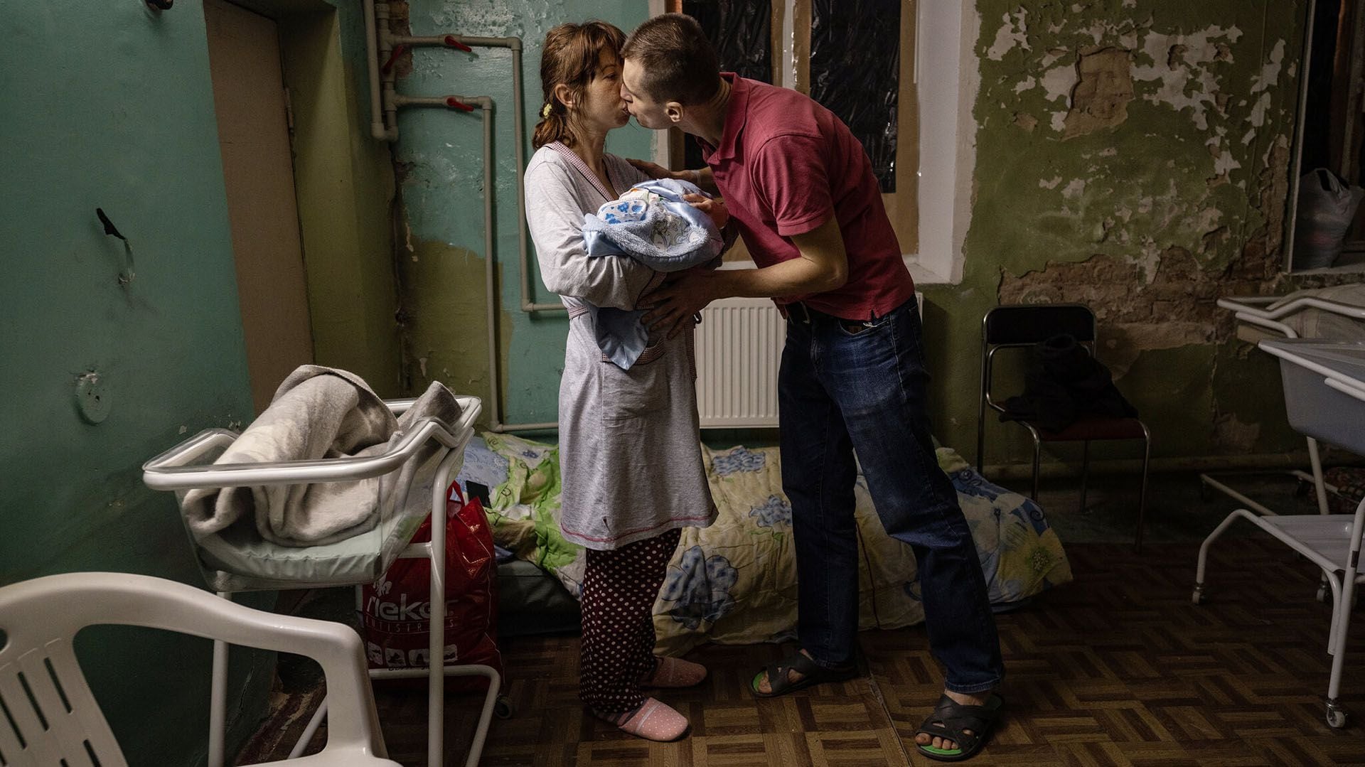 Vladimir Shyian besando a su esposa, Lina Chayka, mientras ella sostenía a su bebé de un día, Maxim, el mes pasado en el refugio del sótano del Hospital de Maternidad nº 5 mientras las sirenas de advertencia sonaban fuera