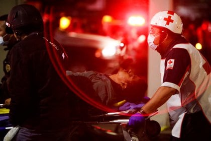 Rescuers transport a casualty on a stretcher at a site where an overpass for a metro partially collapsed with train cars on it at Olivos station in Mexico City, Mexico, May 3, 2021. REUTERS/Luis Cortes