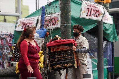 An organ grinder plays in the street during the reopening of business across the city after confinement measures were eased, as the coronavirus disease (COVID-19) outbreak continues, in the Iztapalapa neighborhood in Mexico City, Mexico, August 4, 2020. REUTERS/Henry Romero