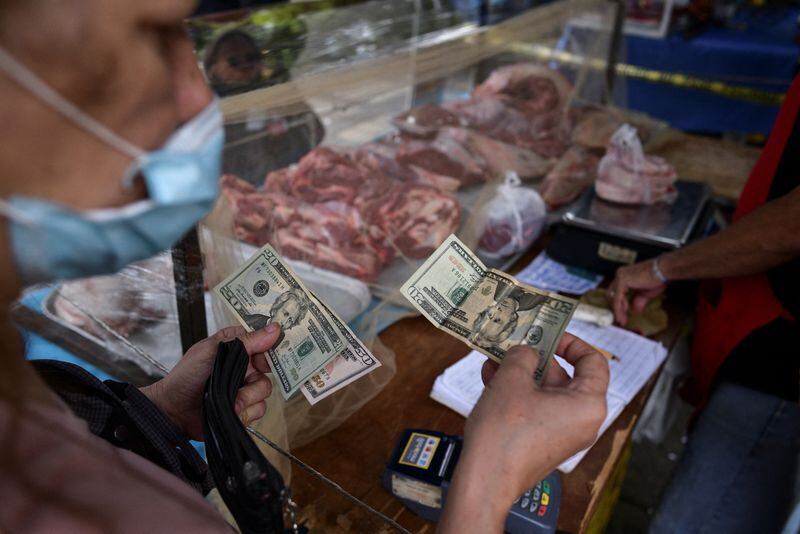 Una persona paga su compra con dólares en Caracas (REUTERS/Gaby Oraa/Archivo)