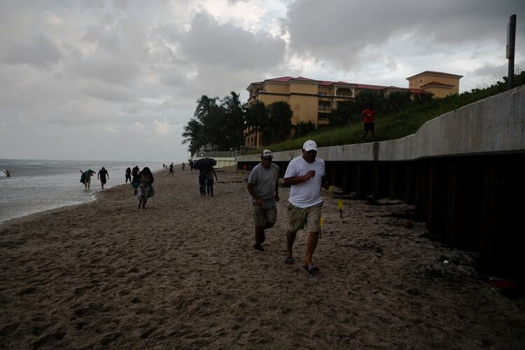 Personas huyen de la playa enÂ Lantana Beach, Florida . (Eva Marie UZCATEGUI / AFP)